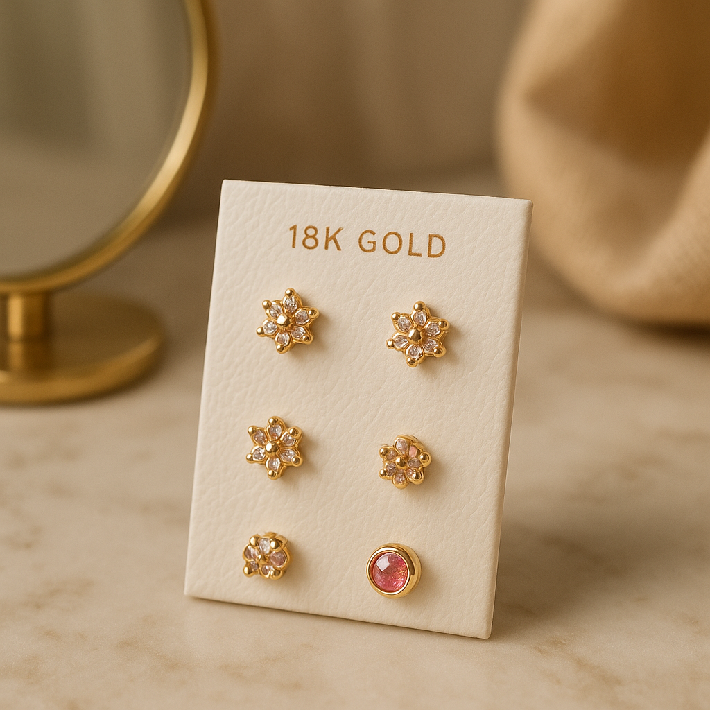 Set of 18K yellow gold baby earrings in various styles and colors on a white card display
