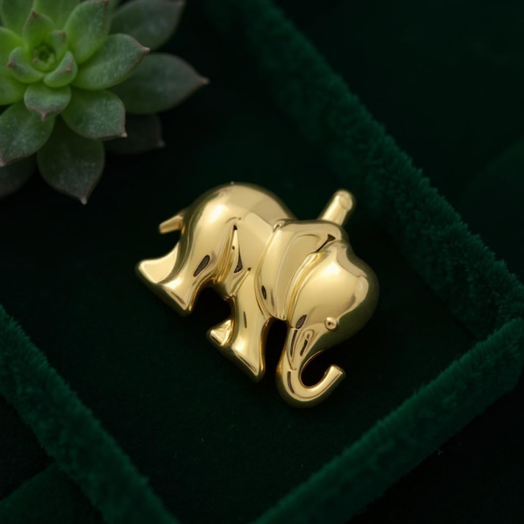 18K yellow gold elephant-shaped pendant symbolizing fortune and elegance in a green velvet box